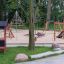 Ensemble de jeux Playhouse Nature avec structures d'escalade et toboggans dans un parc.