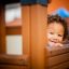 Enfant souriant en jouant dans l'équipement de jeu Playhouse Nature.