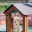Structure de jeu en bois Playhouse Nature pour enfants dans une aire de jeux extérieure.