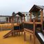Knight's Castle Nature playhouse with slide sur l’aire de jeux.