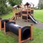 Knight's Castle Nature playhouse with slide et tunnels dans un parc.