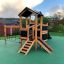 Tower Nature wooden playhouse with slide dans une aire de jeux