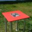 Sand & Water Table avec dessus rouge et bassin en acier inoxydable posé sur l'herbe