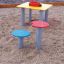 Table and chair dans une aire de jeux pour enfants avec des sièges colorés.