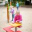 Fille assise sur Square bench and table dans l'aire de jeux.