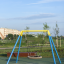 Aire de jeux présentant la Silver Single Swing (BNS) avec un design moderne de siège circulaire.