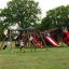 Des enfants jouent sur l’aire de jeux château Mastodon avec toboggan.