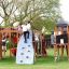 Des enfants jouent sur le château Mastodon avec toboggan dans une aire de jeux.