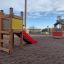 Structure de jeu en bois Toddler Tower Slide avec toboggan rouge dans une aire de jeux.