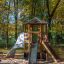 Ensemble de jeux en bois Six Angle Aztec avec toboggans et mur d’escalade dans le parc.