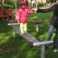 Enfant en équilibre sur la poutre Wonderland Trim Trail dans une aire de jeux.