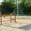 Des enfants jouent sur Classic Nature Trim Trail dans une aire de jeux avec une pyramide d'escalade en corde.