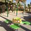 Équipement de jeu vert et jaune Clover rocking dans une aire de jeux ensoleillée