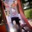 Deux enfants jouant sur une maison de jeu locomotive avec un toboggan.