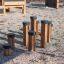 Équipement de terrain de jeu en bois Jumping pegs sur une surface en gravier.