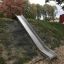 Hill Slide h210 sur une pente herbeuse dans une aire de jeux de parc