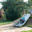 Enfant glissant sur un Hill Slide Wide h150 dans une aire de jeux.
