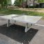 Table de tennis de table autoportante en béton dans un parc.