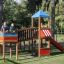 Des enfants jouent sur le Jubilee Unit castle with slide dans un parc.