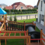 Des enfants jouent sur le Jubilee Unit castle with slide dans un jardin.