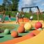 Des enfants jouent sur Swing Frame (double swing) dans une aire de jeux colorée.
