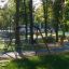 Swing Frame (double swing) dans un parc verdoyant et ensoleillé avec des arbres en arrière-plan