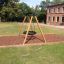 Swing Frame (single swing, wide) dans une aire de jeux herbeuse avec base en copeaux de bois