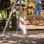 Des enfants jouent sur un Swing Metal Frame (single swing, wide).