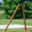 Swing seat: Safety seat sur une structure de balançoire en bois dans un parc herbeux