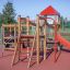 Aire de jeux extérieure Lemur single slide avec structure rouge et en bois.
