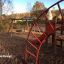 Panther wooden playhouse dans une aire de jeux avec des balançoires et des structures d’escalade en arrière-plan