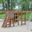 Panther wooden playhouse dans une aire de jeux avec des structures d’escalade et des échelles