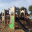 Aire de jeux pour enfants Camelot castle with slide dans une zone sablonneuse