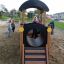 Des enfants jouent sur le Locomotive Nature train playhouse dans un bac à sable.