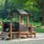 Locomotive Nature train playhouse sur une aire de jeux avec un enfant qui joue à l’intérieur.