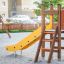 Toboggan jaune Pi avec marches en bois dans une zone de bac à sable