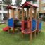 Smart playhouse with slide dans un cadre d’aire de jeux.