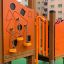 Smart playhouse with slide en orange avec diverses formes et éléments d’escalade