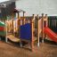 Rubik playhouse with slide dans une aire de jeux.