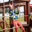 Enfant jouant sur la structure de jeux Grocer's single sliderope.