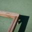 Structure en bois 'Balance' placée sur une surface verte.