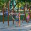 Des enfants jouent sur une échelle en bois d'un rack d'entraînement extérieur en bois dans une aire de jeux.