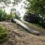 Toboggan d'extérieur Hill Slide STS 210 entouré d'arbres et de verdure.
