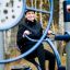 Femme faisant de l’exercice sur un équipement de gym extérieur Set 6 dans un parc.