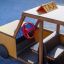 Taxi en bois pour aire de jeux avec un volant rouge.