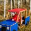 Des enfants jouent dans un équipement de jeu en bois sur le thème du camion.