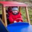 Des enfants jouent dans un jouet en bois Truck sur un terrain herbeux.