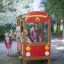 Des enfants jouent sur un équipement de jeu Fire brigade car dans un parc.