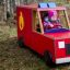 Des enfants jouent dans un Fire brigade truck sur l’herbe.