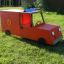 Camion de pompiers jouet rouge sur l’herbe.
